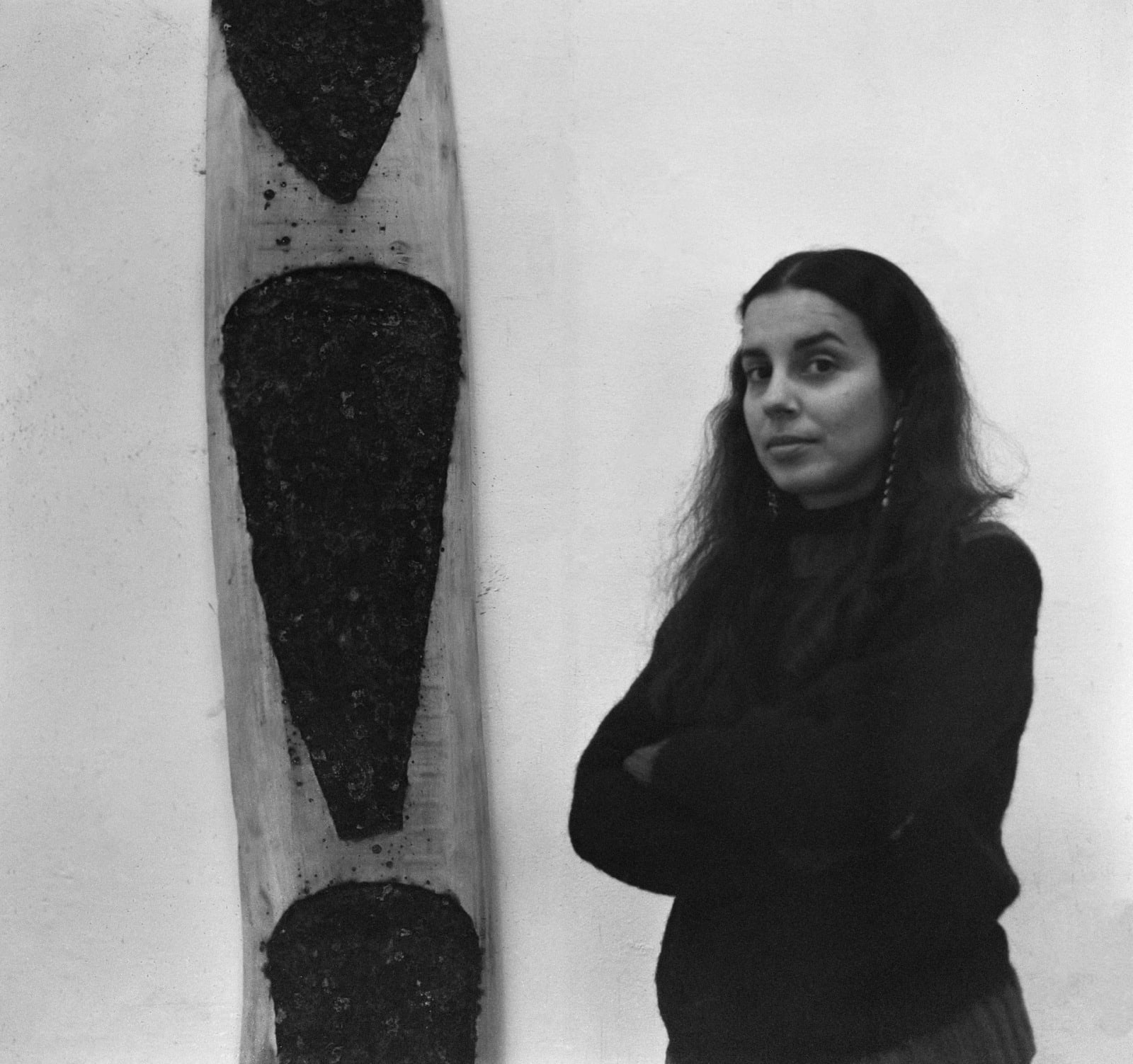portrait of Ana Mendieta beside one of her works